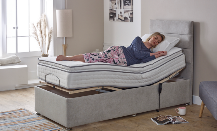 A woman relaxes on an adjustable bed, comfortably lying on a soft mattress in a cozy bedroom setting.
