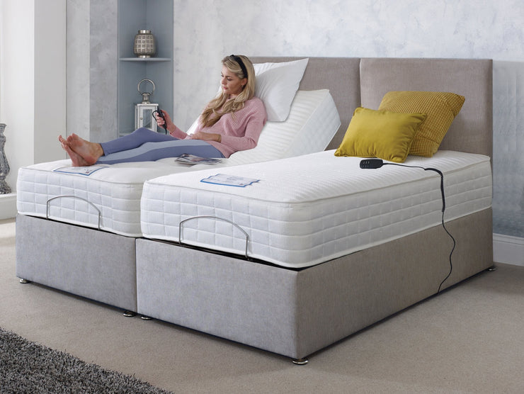 A woman relaxes on an adjustable bed, using a controller to change its position for optimal comfort.