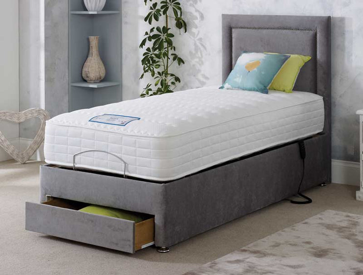 A grey adjustable bed featuring a comfortable mattress and convenient drawers for storage underneath.